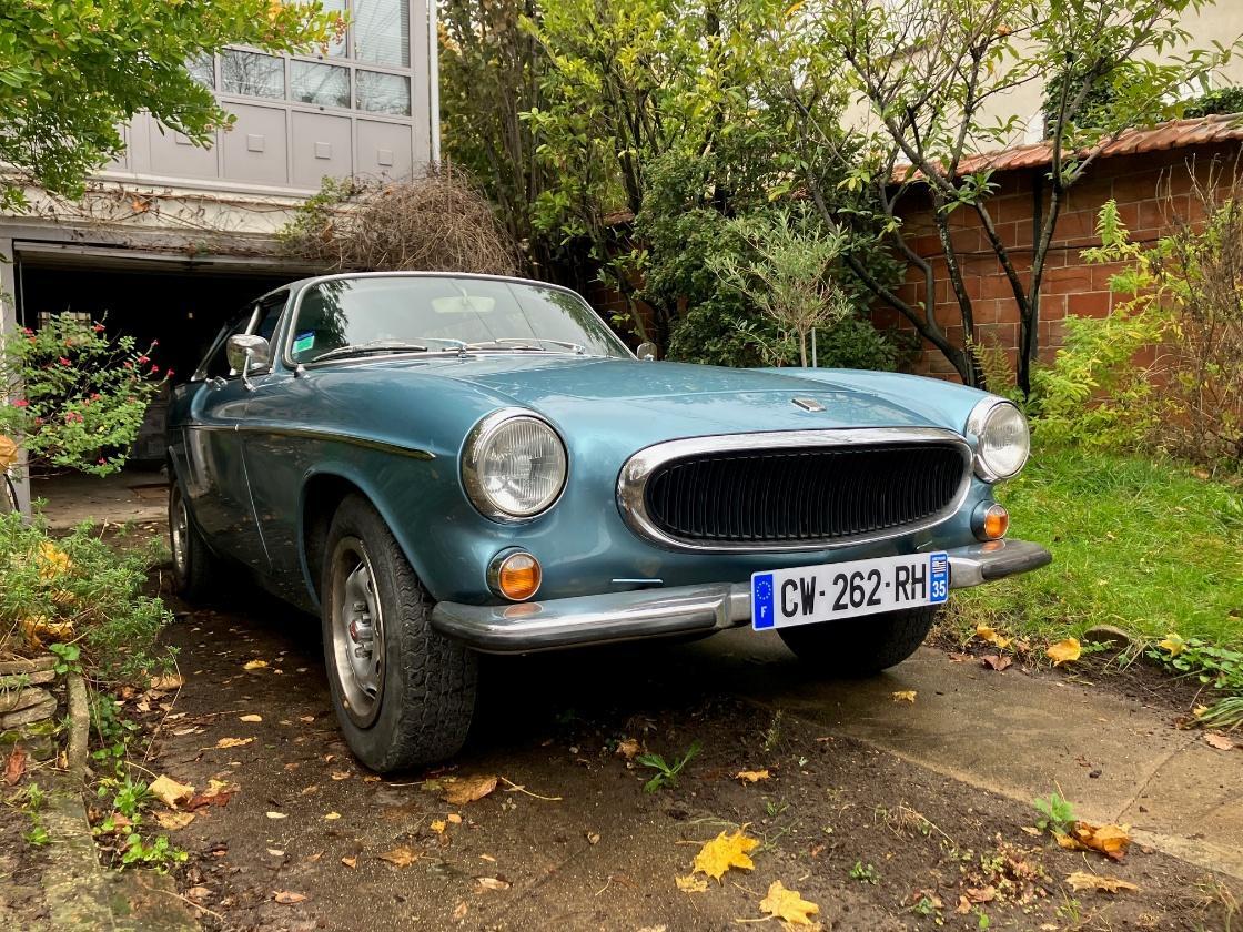 Simon’s blue Volvo P1800ES parked outside the garage